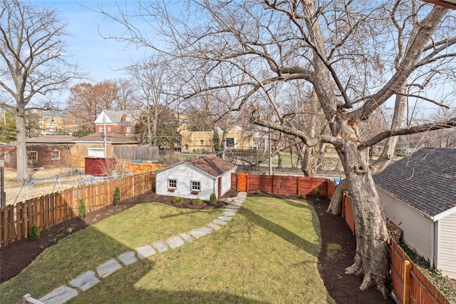 view of yard with an outdoor structure, a fenced backyard, and a residential view