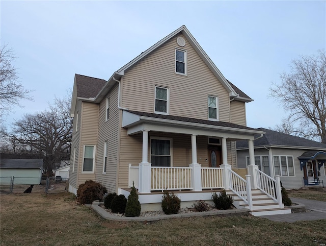 view of front of home with covered porch, fence, and a front yard