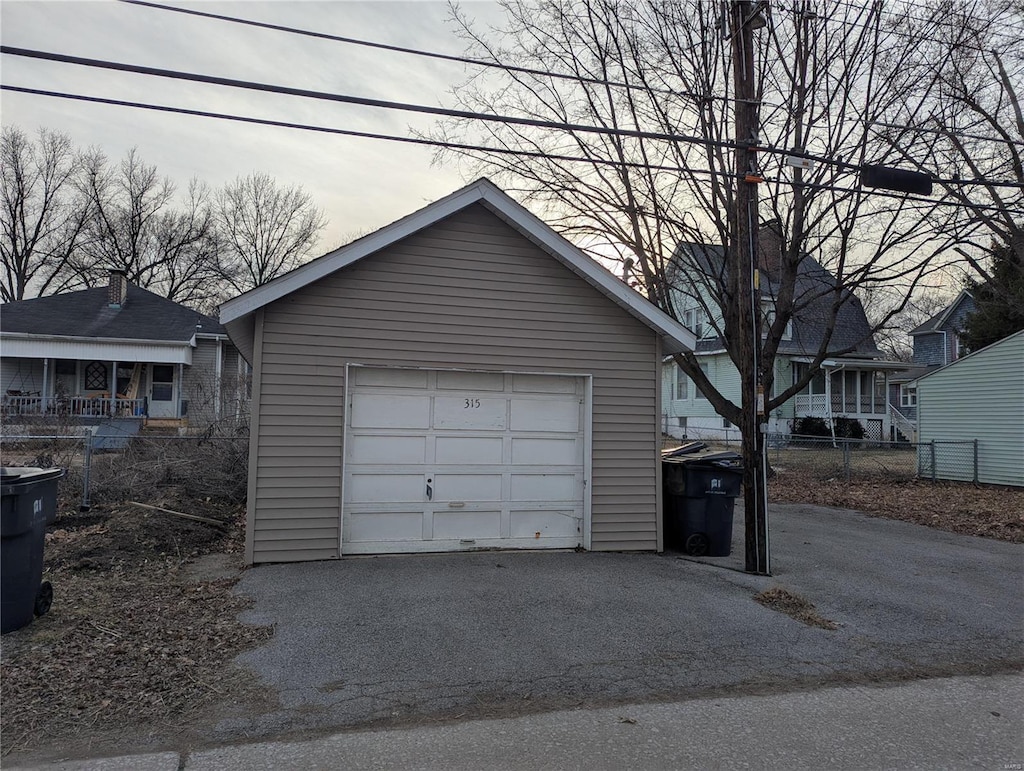 detached garage with driveway and fence