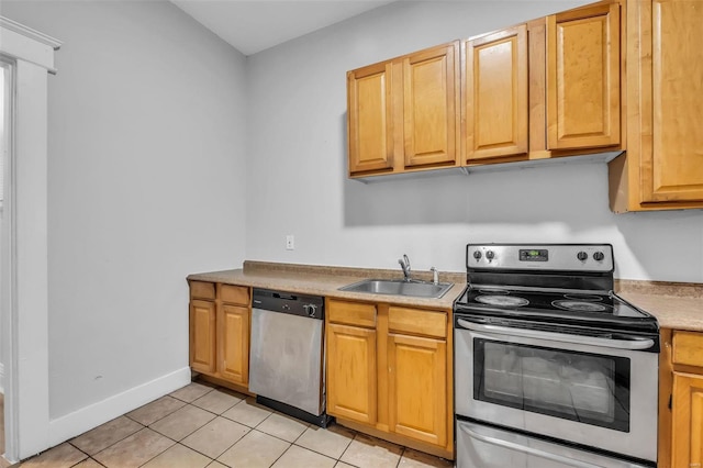 kitchen with sink, light tile patterned floors, and stainless steel appliances