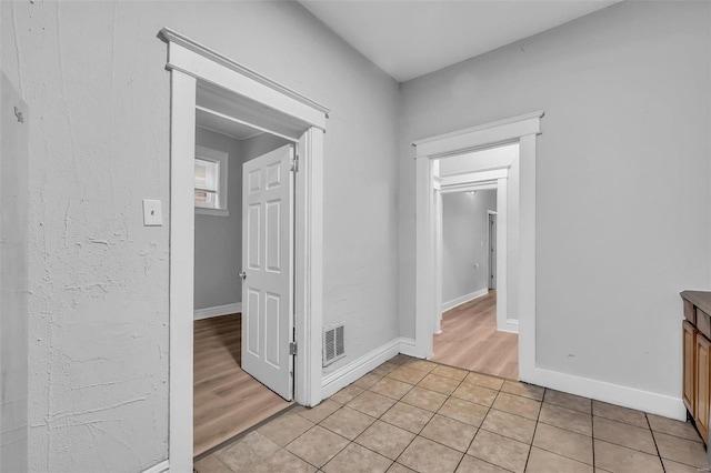 corridor featuring light tile patterned floors