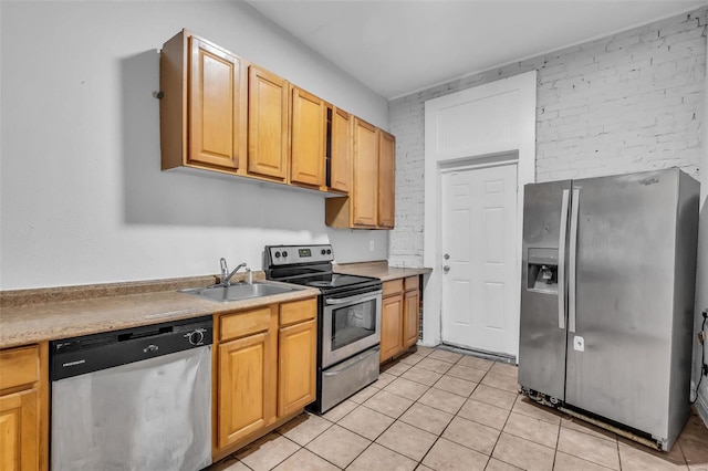 kitchen featuring light tile patterned flooring, appliances with stainless steel finishes, and sink