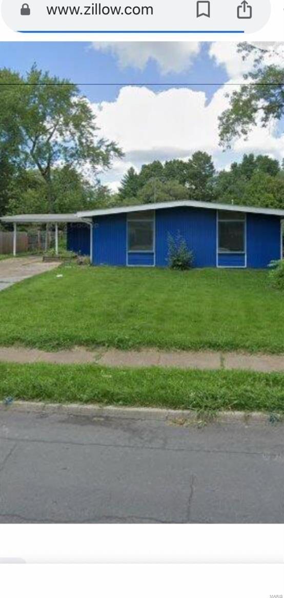 view of front facade with a front lawn and a carport