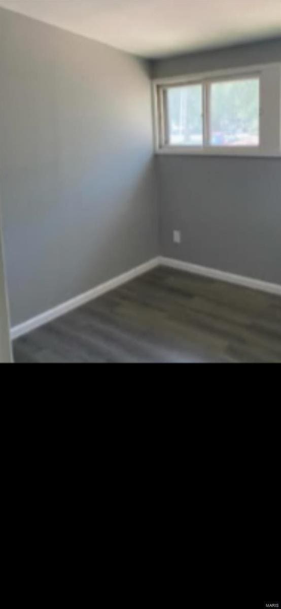 empty room with baseboards and wood finished floors