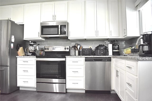 kitchen with white cabinetry, appliances with stainless steel finishes, and tasteful backsplash