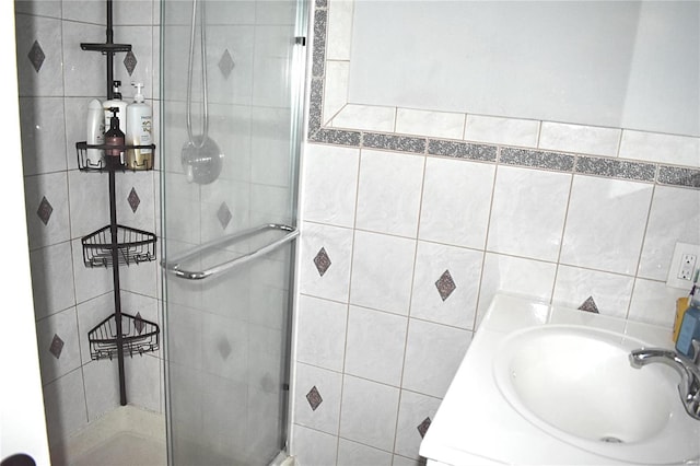 bathroom with sink, tile walls, and walk in shower