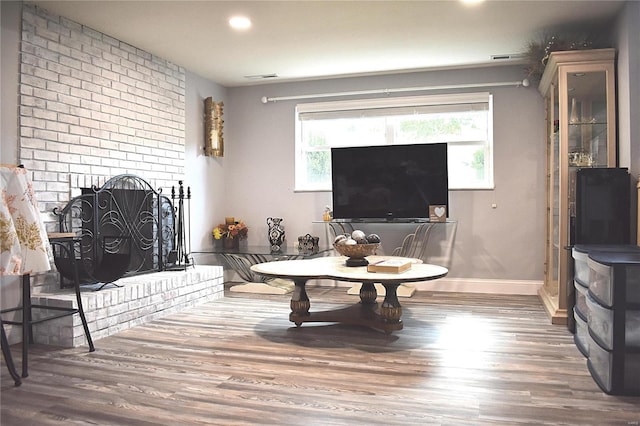 living room featuring wood-type flooring and a fireplace