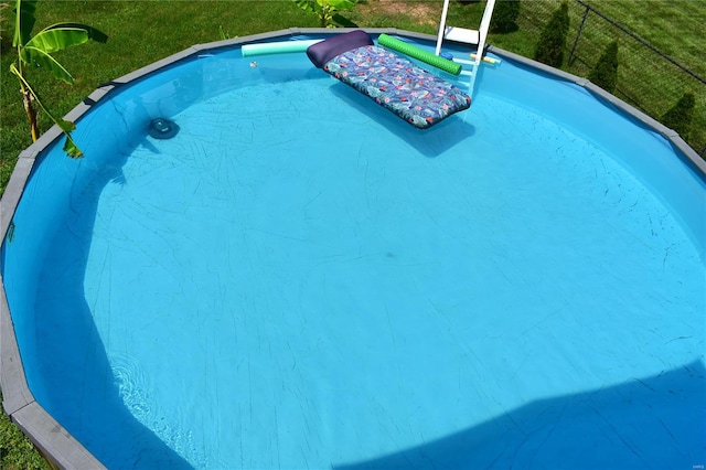 view of pool featuring a lawn