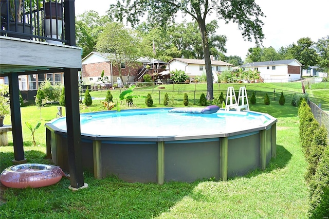 view of swimming pool featuring a yard