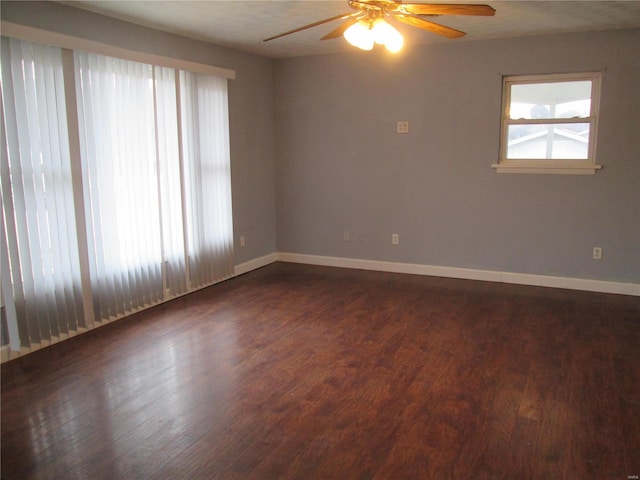 spare room with plenty of natural light, dark wood-type flooring, and ceiling fan