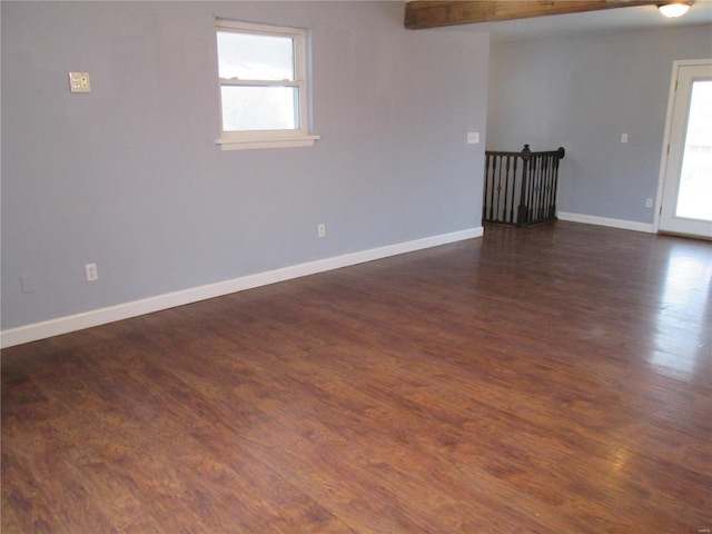 empty room featuring plenty of natural light and dark hardwood / wood-style floors