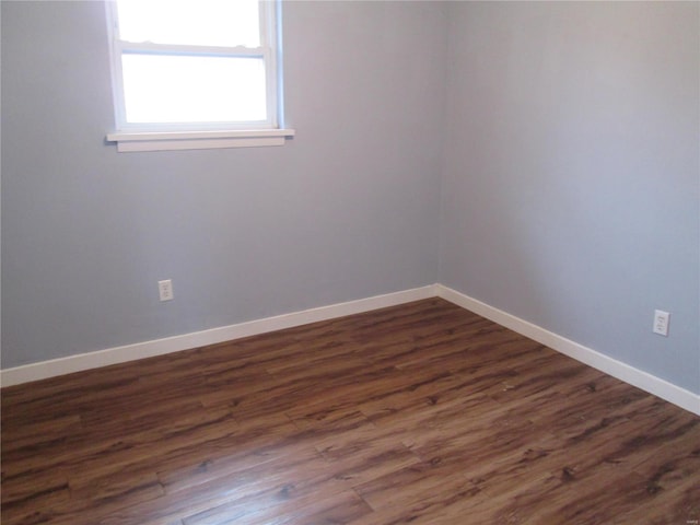 unfurnished room with dark wood-type flooring