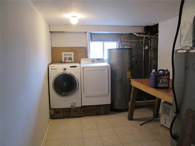 clothes washing area featuring water heater, light tile patterned flooring, and washer and dryer