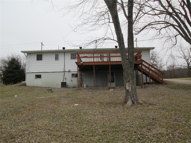 rear view of property featuring a wooden deck, central AC unit, and a lawn