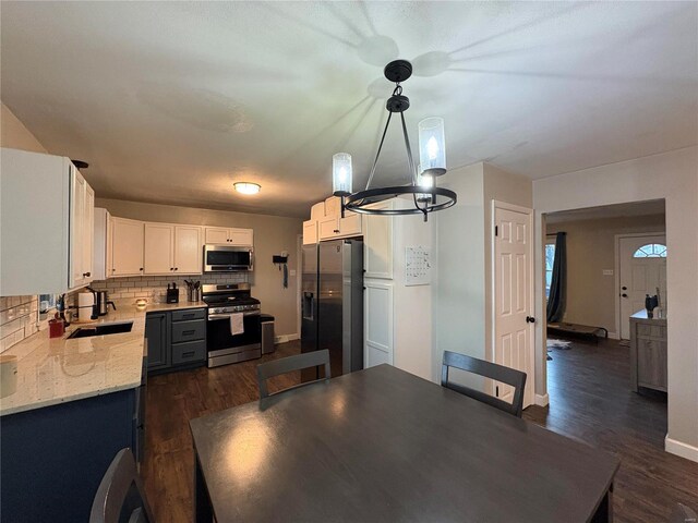 unfurnished dining area with dark hardwood / wood-style floors, a chandelier, and sink