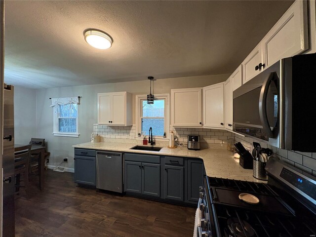 kitchen featuring sink, gray cabinets, white cabinetry, hanging light fixtures, and stainless steel appliances