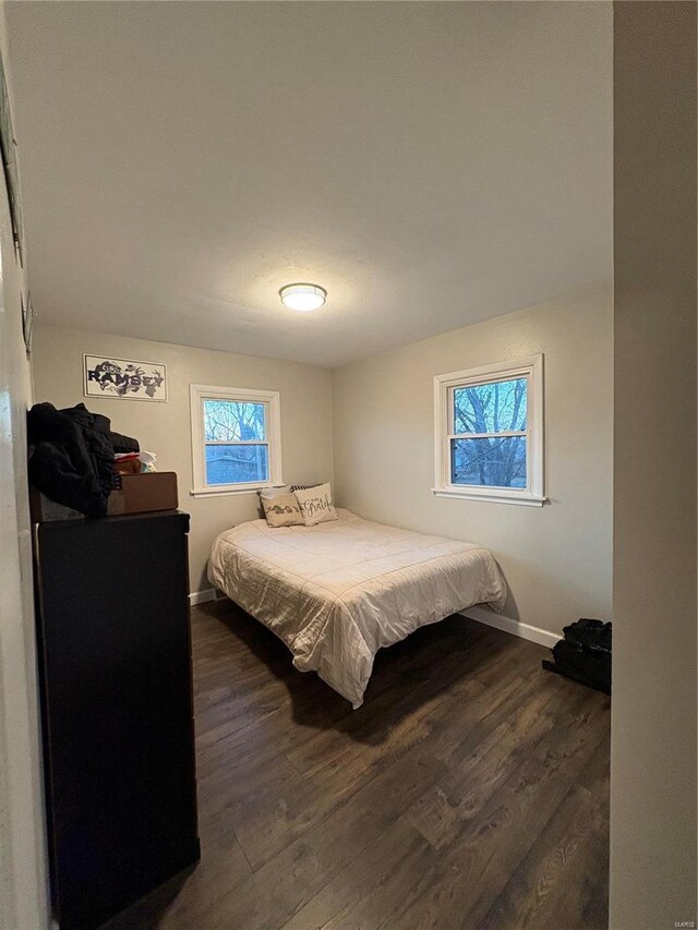 bedroom with dark hardwood / wood-style floors