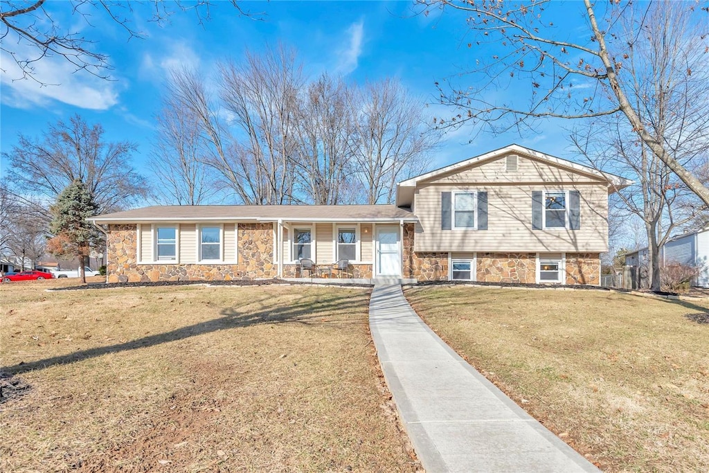 tri-level home featuring a front yard and covered porch