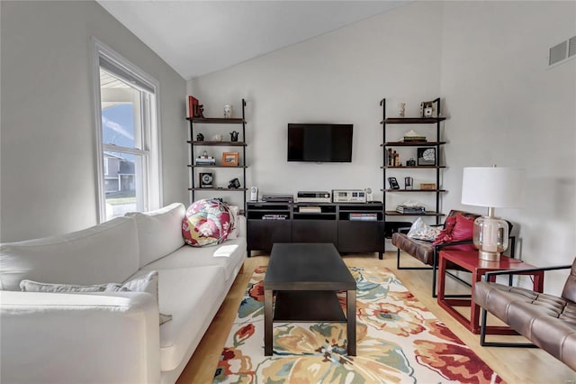 living room featuring vaulted ceiling and light hardwood / wood-style floors