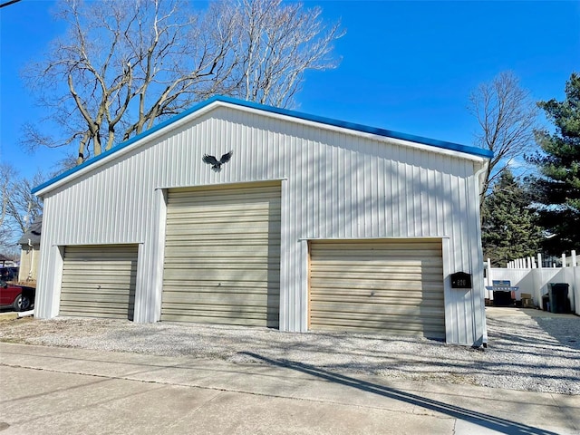 detached garage featuring fence