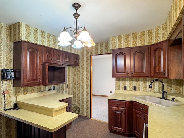 kitchen featuring sink, dark colored carpet, an inviting chandelier, and pendant lighting