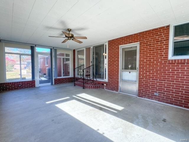 unfurnished sunroom with ceiling fan