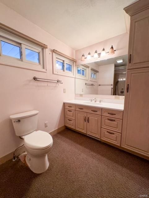 bathroom with toilet, vanity, and walk in shower