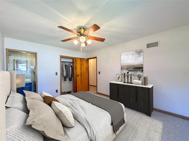 carpeted bedroom with a textured ceiling, a closet, and ceiling fan