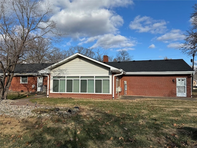 rear view of property with a lawn