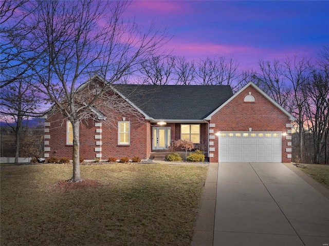 ranch-style house with a garage and a yard