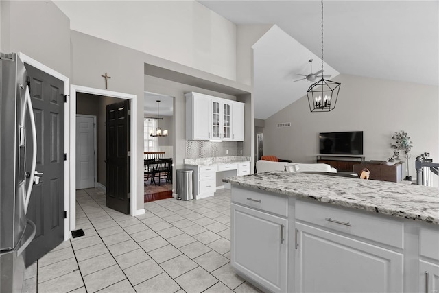 kitchen featuring stainless steel refrigerator with ice dispenser, a notable chandelier, pendant lighting, and white cabinets