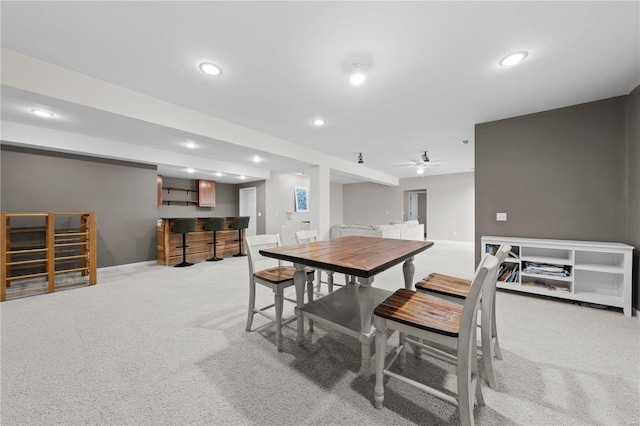 carpeted dining space featuring bar area