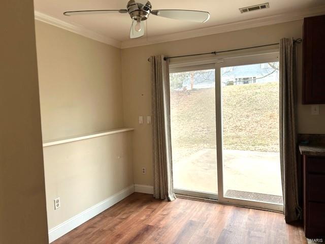 entryway with hardwood / wood-style floors, ornamental molding, and ceiling fan