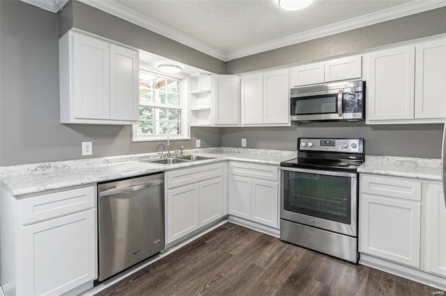 kitchen with appliances with stainless steel finishes, sink, white cabinets, dark hardwood / wood-style flooring, and crown molding