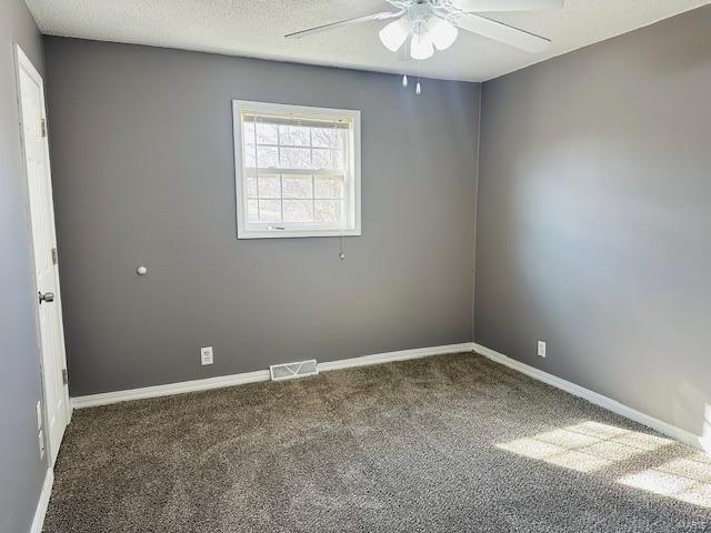 unfurnished room featuring ceiling fan, carpet, and a textured ceiling