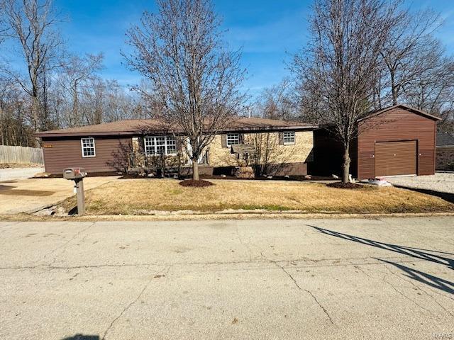 single story home with a garage, an outdoor structure, and a front yard