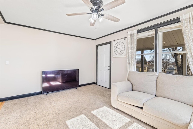 carpeted living room featuring ornamental molding and ceiling fan