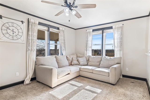 carpeted living room featuring crown molding, ceiling fan, and a wealth of natural light