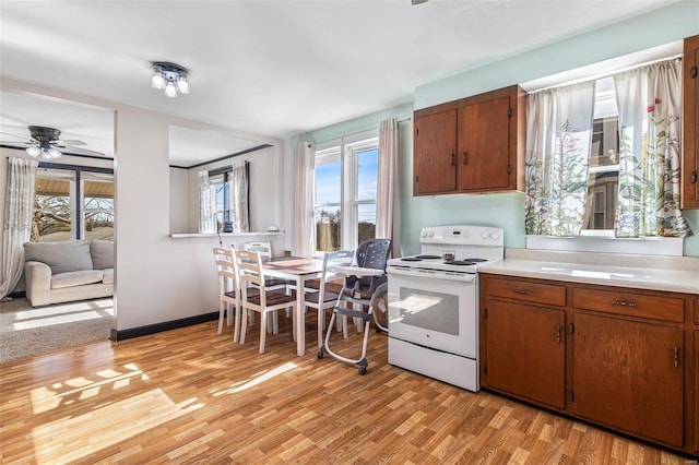 kitchen featuring ceiling fan, white electric range, and light hardwood / wood-style floors