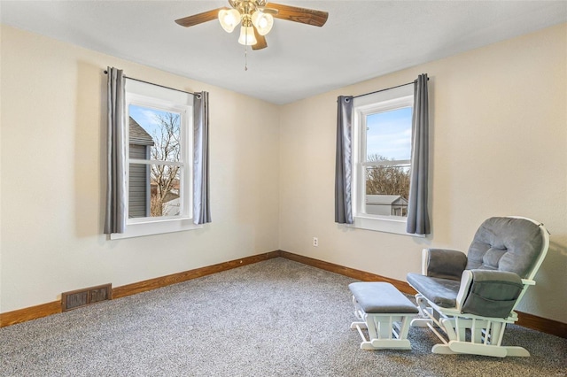 living area with plenty of natural light, ceiling fan, and carpet flooring