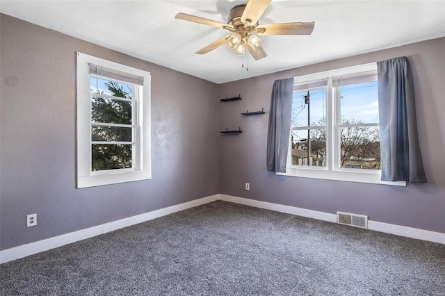 unfurnished room with ceiling fan and carpet