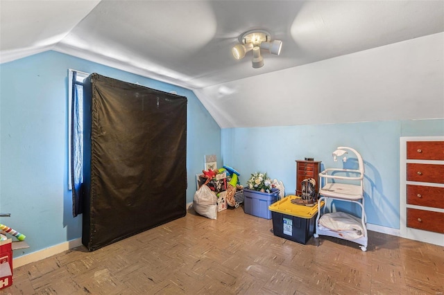 recreation room featuring parquet floors and vaulted ceiling