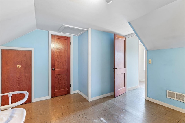 additional living space featuring light parquet flooring and vaulted ceiling