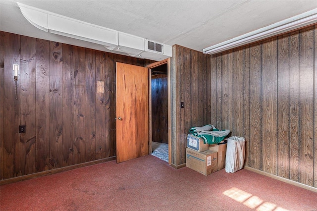 interior space with carpet flooring and wooden walls