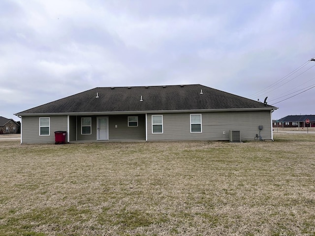 rear view of house featuring a yard and central air condition unit