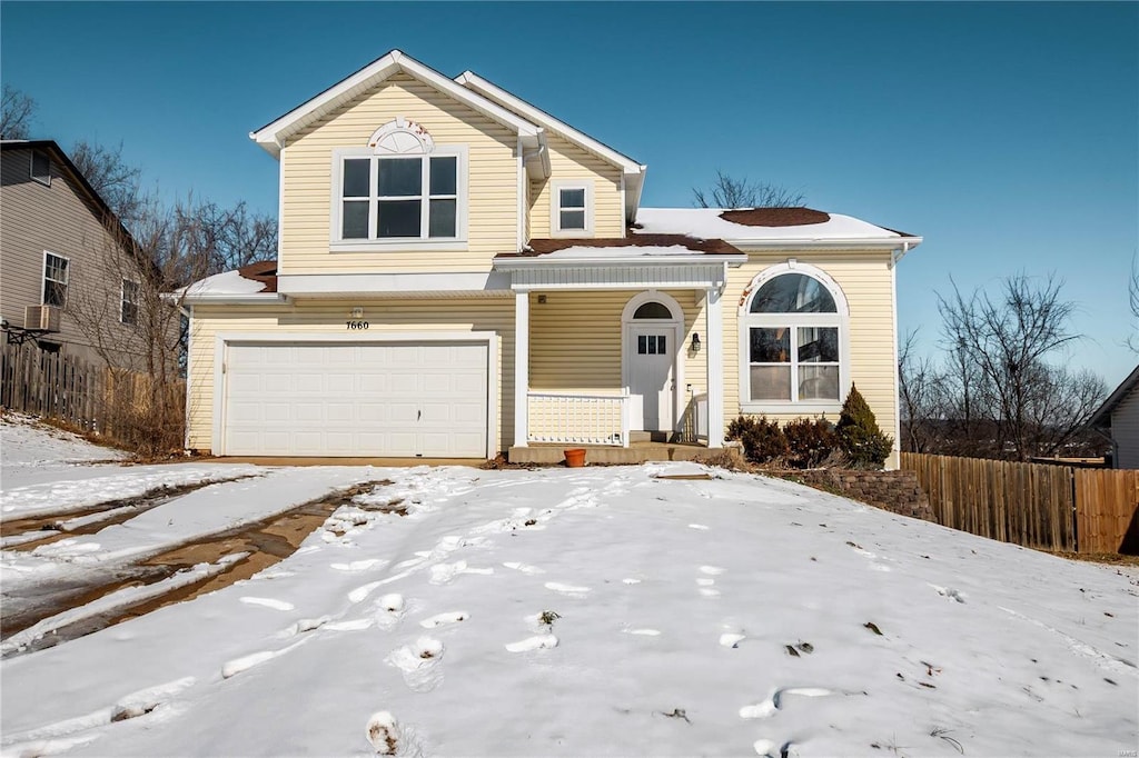 traditional-style home featuring an attached garage and fence