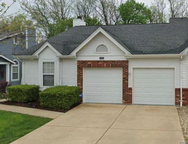 ranch-style home with brick siding, roof with shingles, a chimney, concrete driveway, and an attached garage