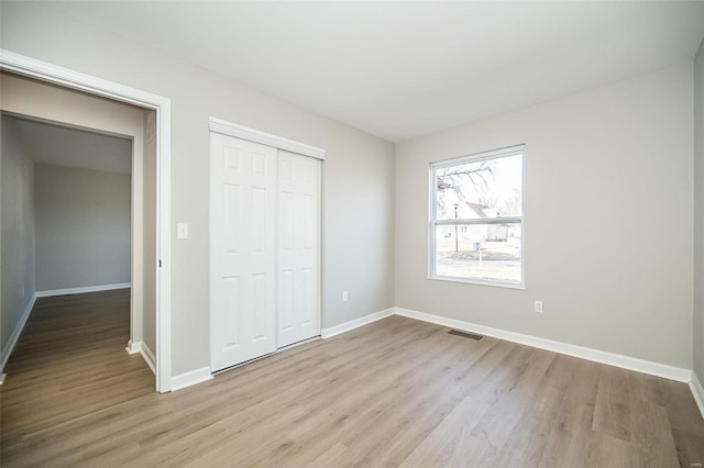 unfurnished bedroom featuring a closet and light hardwood / wood-style flooring