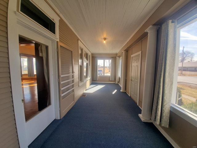 hall with wooden ceiling and dark colored carpet