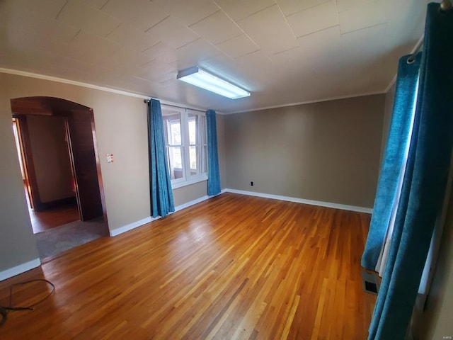 spare room featuring crown molding and hardwood / wood-style floors